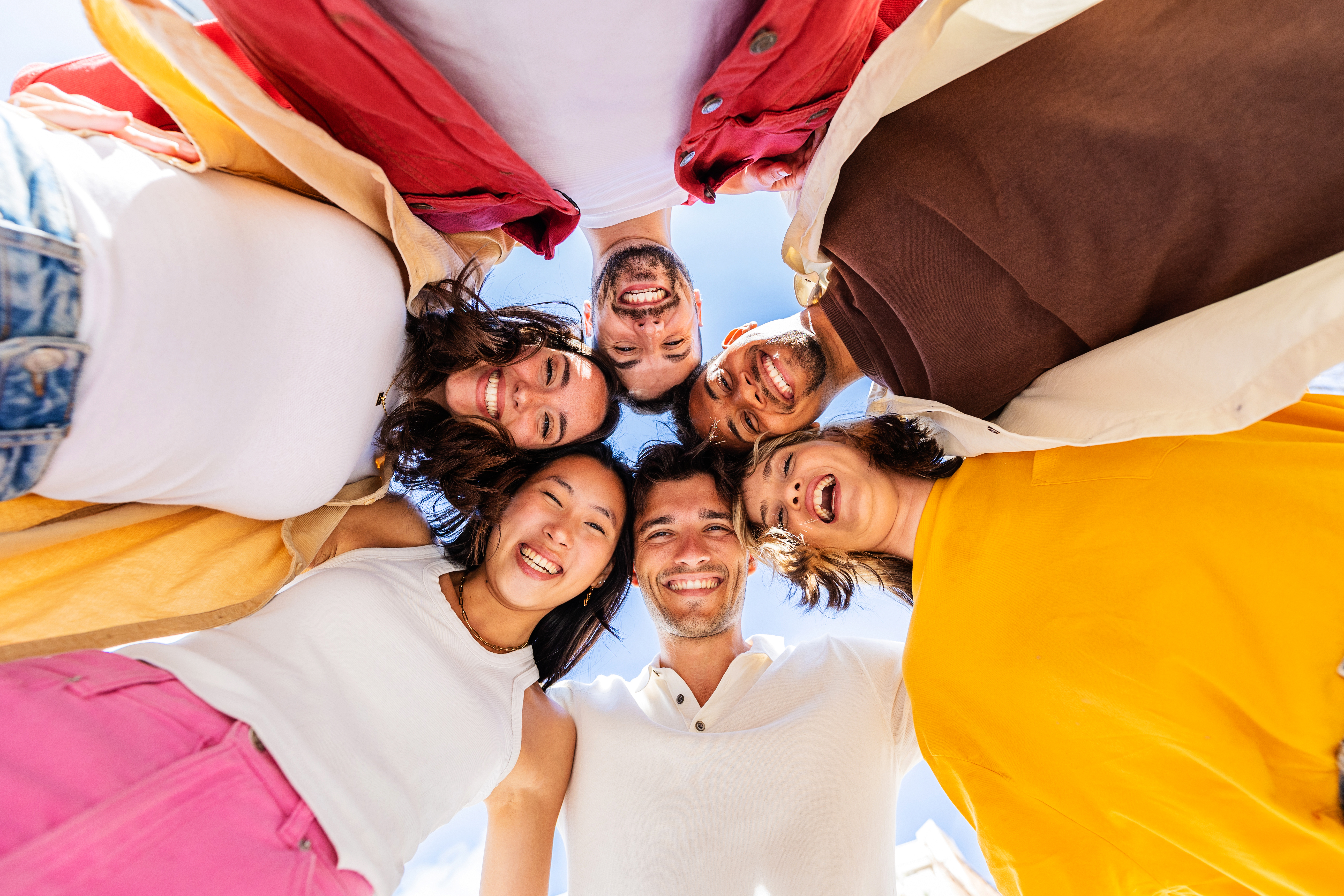 Happy group of young people in circle. Diverse friends having fun together outside. Friendship, diversity and community concept.